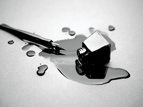 old fashioned pen with a glass of spilled black ink
